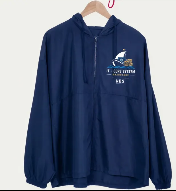 Jaket hoodie zipper berwarna biru navy yang digantung, dilengkapi sablon logo kapal dan teks IT - Core System Guardians NDS pada bagian dada kiri.