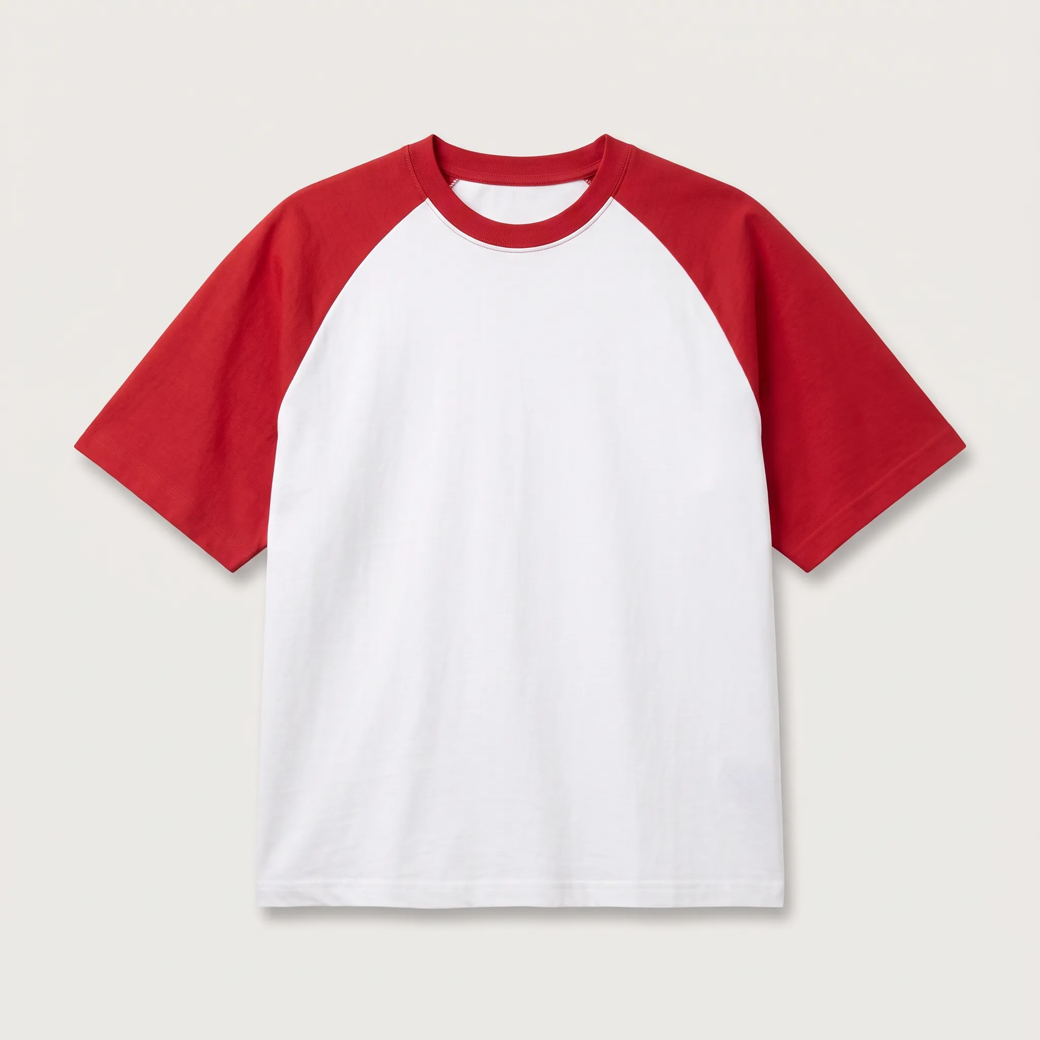 Contoh kaos model raglan lengan pendek dengan kombinasi warna lengan merah dan badan putih, menampilkan potongan jahitan diagonal yang khas dari bahu ke ketiak.